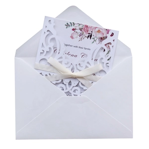 Detailed set of laser-cut wedding invitations with floral inserts and silk ribbons