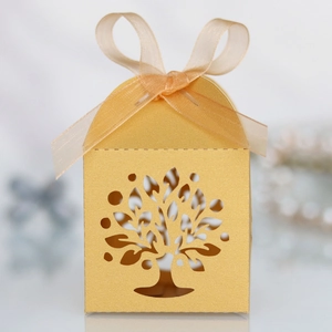 Close-up of laser-cut Tree of Life candy box with elegant gold finish and ribbon
