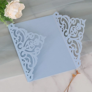 Detail of light blue laser-cut invitation card with floral patterns on pearlescent paper