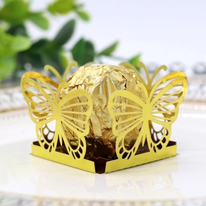 Macro shot of gold hollow butterfly candy holder with intricate laser-cut wing texture