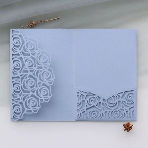 Detail of light blue laser cut rose floral hollow design on luxury wedding invitation