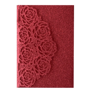 Detail of red glitter laser-cut invitation cover featuring intricate rose patterns