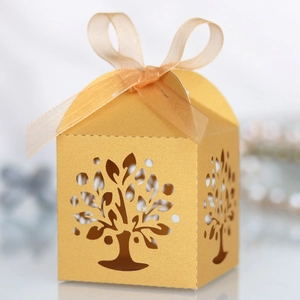 Close-up of golden laser-cut tree gift box with elegant organza ribbon bow
