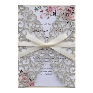 Laser-cut silver glitter wedding invitation with white ribbon and floral inner card