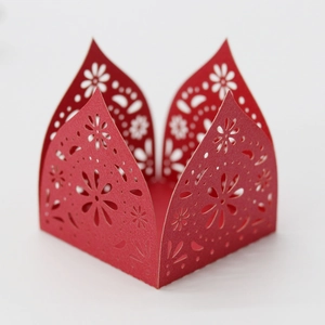 Macro view of laser-cut red pearlescent cardstock gift box with floral lace patterns