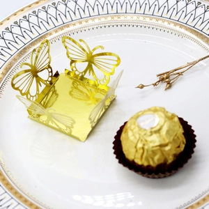 Detail of laser-cut gold hollow butterfly cupcake liners for wedding candy decoration