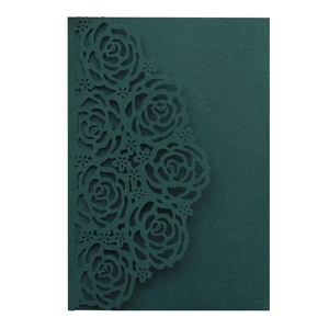 Detail of dark green laser-cut wedding invitation featuring elegant rose flower patterns