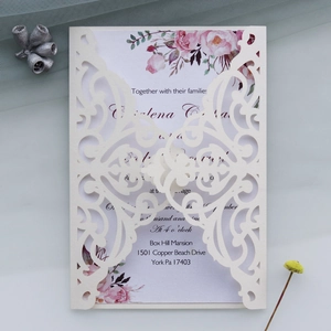 Detailed close-up of ivory laser-cut floral wedding invitation with purple rose insert card