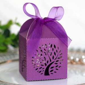 Detail of purple laser-cut tree candy box with an elegant organza ribbon bow