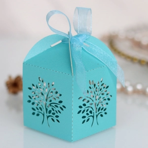 Close-up of laser-cut tree design on light blue candy box with matching ribbon bow