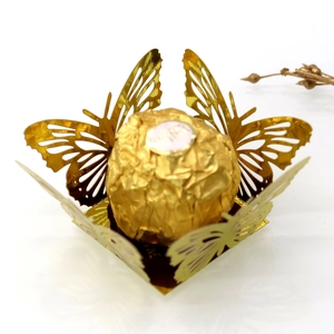 Detail showing laser-cut gold butterfly candy wrapper for party chocolate decorations