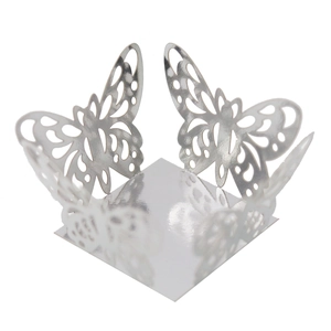 Macro view of silver laser-cut butterfly cupcake wrapper and festive hollow candy box base