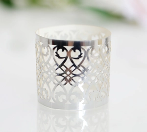 Close-up of laser-cut silver cupcake wrappers with elegant hollow vine patterns