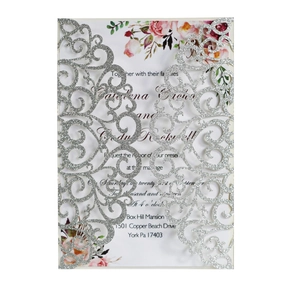Detail of silver glitter laser-cut wedding invitation with elegant floral inner card