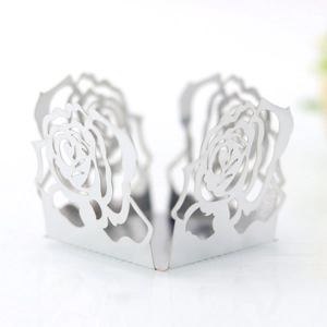 Détail de la caissette à cupcake en papier blanc avec motif de rose découpé au laser