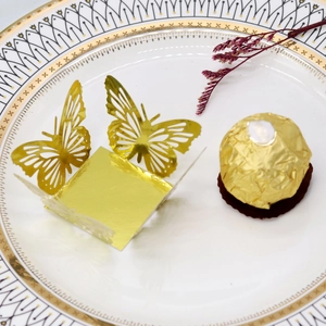 Detailed close-up of a hollowed golden butterfly paper wrapper for wedding chocolate