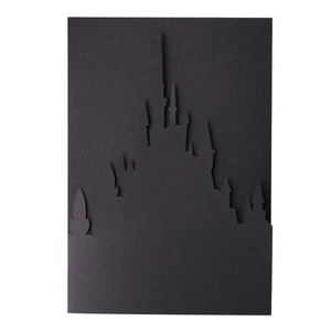 Macro view of laser-cut black castle silhouette wedding invitation card decoration