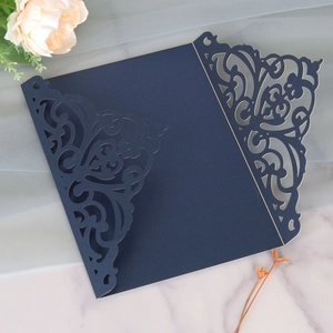 Macro view of navy blue laser-cut wedding invitation featuring intricate floral scrolls