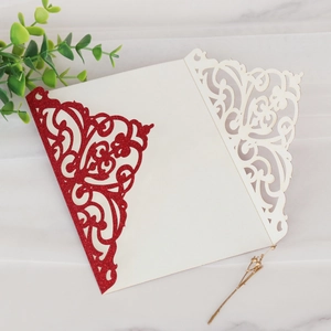 Motif floral découpé au laser sur invitation à paillettes rouges avec décor de feuilles