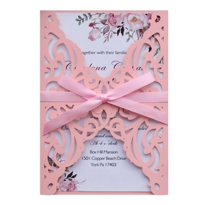 Elegant laser cut wedding invitation with floral insert and pink ribbon bow decoration