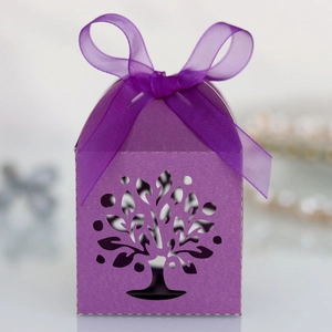 Detailed laser-cut tree of life pattern on purple wedding favor box with silk ribbon