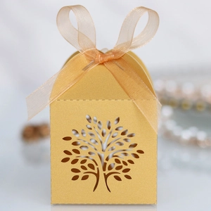 Detail of laser-cut Tree of Life candy box in gold finish with an elegant ribbon bow