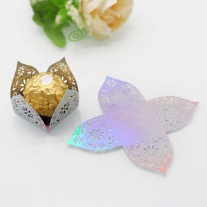 Detail of laser cut hollow mirror gold candy box with intricate lace floral patterns