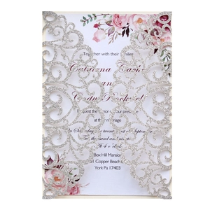 Detail of silver glitter laser cut wedding invitation with elegant floral inner card