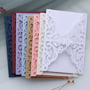 Macro view of precision laser-cut baroque vine patterns on colorful invitation cards