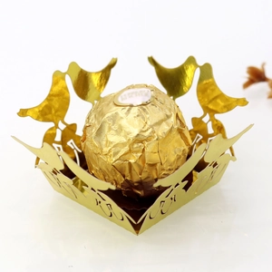 Macro shot of gold laser-cut bird hollow chocolate wrapper with elegant lace design