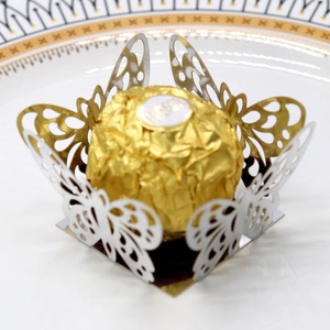 Macro detail of hollow laser-cut butterfly cupcake wrappers in gold and silver finish