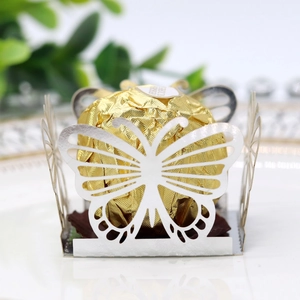 Macro shot of laser-cut white butterfly candy holder featuring a gold foil chocolate