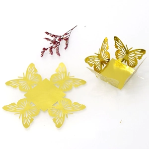 Detail of laser-cut hollow golden butterfly candy box with reflective mirror finish
