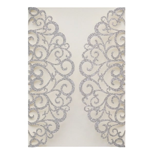 Macro detail of laser-cut glitter wedding invitation with ornate silver vine pattern