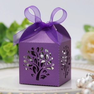 Macro view of purple laser-cut candy box with tree pattern and satin ribbon bow