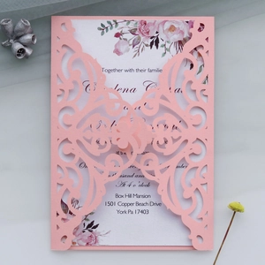 Detail of pink laser-cut wedding invitation with elegant floral printed inner card