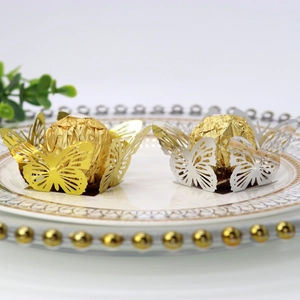 Detailed laser-cut butterfly chocolate decor in gold and silver for wedding party table settings