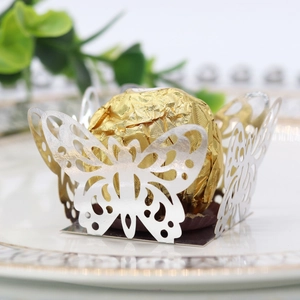 Detailed laser-cut silver butterfly favor box holding a gold foil chocolate ball