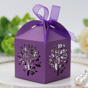 Detail showing laser-cut tree design on a purple favor box with elegant silk ribbon