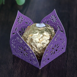 Detail of purple laser-cut paper chocolate wrapper with intricate floral hollow pattern