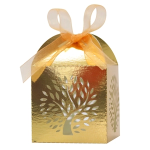 Close-up of golden tree of life laser-cut candy box with orange organza ribbon bow