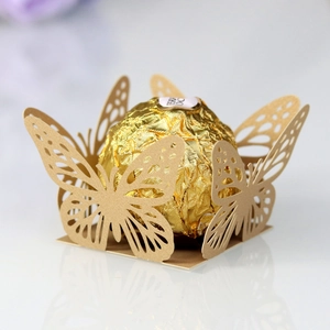 Detail of laser-cut gold butterfly chocolate wrappers for wedding candy decorations