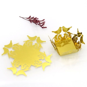 Detail of golden laser-cut candy box with hollow birds for wedding party decoration