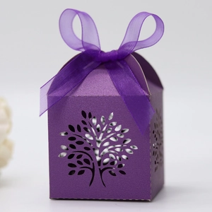 Detail view of purple hollowed tree laser cut candy box with shimmering pearl paper and ribbon