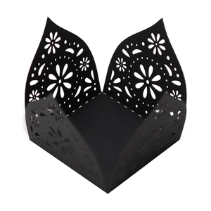 Close-up of black laser-cut hollow floral lace patterns on a decorative candy gift box