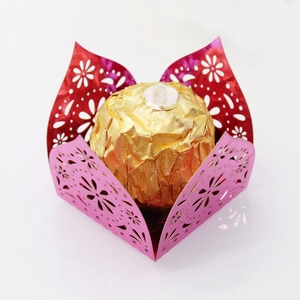 Macro detail of laser-cut hollow chocolate wrappers with floral patterns in red and pink