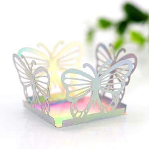 Macro detail of holographic laser-cut butterfly candy box with iridescent finish