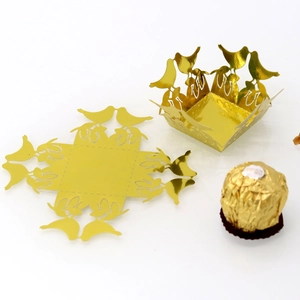 Detail showing golden laser-cut paper candy box with intricate love bird hollowed pattern