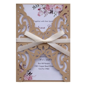 Elegant laser-cut floral wedding invitation with kraft sleeve and white ribbon bow