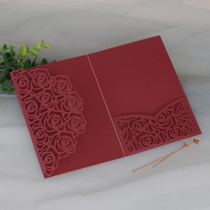 Detailed laser-cut burgundy rose patterns on premium wedding invitation cover